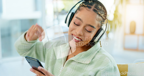 Image of Phone, dance and happy woman on music headphones in home living room. Smartphone, radio and African person listening to podcast, audio and sound for freedom, celebration and streaming media online