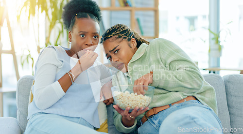 Image of Scary, movie and friends on sofa in living room with popcorn, snack or delicious in house. Black woman, people and together by watching tv, horror or film with expression on face by sitting on couch