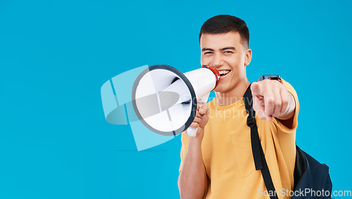 Image of Megaphone, mockup and portrait of man in studio pointing for announcement, speech or rally. Smile, protest and male student from Canada with bullhorn for communication isolated by blue background.