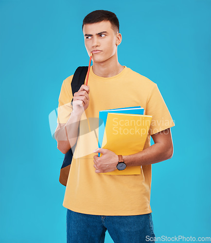 Image of Man, student thinking and choice for college, university or scholarship with books, research and funding solution in studio. Person with decision, confused or ideas for education on a blue background