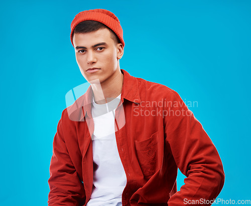 Image of Serious, fashion and portrait of man on a blue background for stylish, trendy or cool clothes. Outfit, shirt and a person or male model in clothing for a casual aesthetic with confidence on backdrop