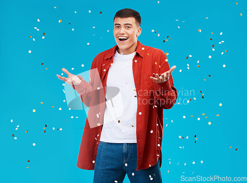 Image of Portrait, confetti and man with celebration, achievement and excited on a blue background. Person, guy and model with sparkle, success and happiness with surprise, wow and omg with victory or winning