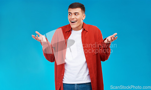 Image of Confused, shrug and young man in a studio with options, decision or comparison expression. Shock, balance and male model from Canada with doubt hand gesture isolated by blue background with mockup.