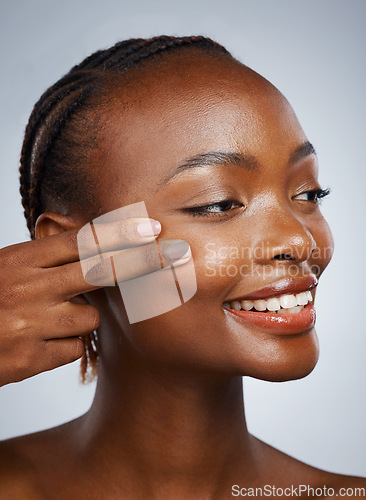 Image of Face, skincare and fingers on the cheek of a black woman in studio on a gray background for beauty or natural wellness. Skin, spa or luxury and a young model with cosmetic or antiaging treatment