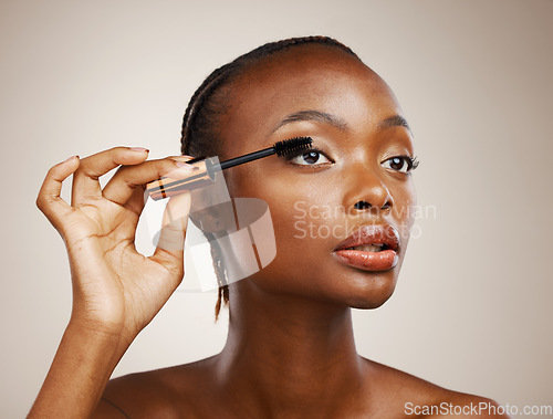 Image of Mascara, black woman and makeup for beauty cosmetics, makeover and eyelash extension in studio on brown background. Face, model and brush lashes for volume, skincare application and aesthetic tools