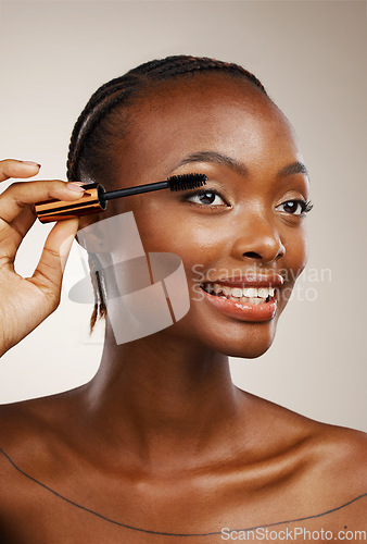 Image of Mascara, happy woman and makeup in studio for beauty, cosmetics and smile on brown background. African model, makeover and brush lashes for skincare application, aesthetic tools and eyelash extension