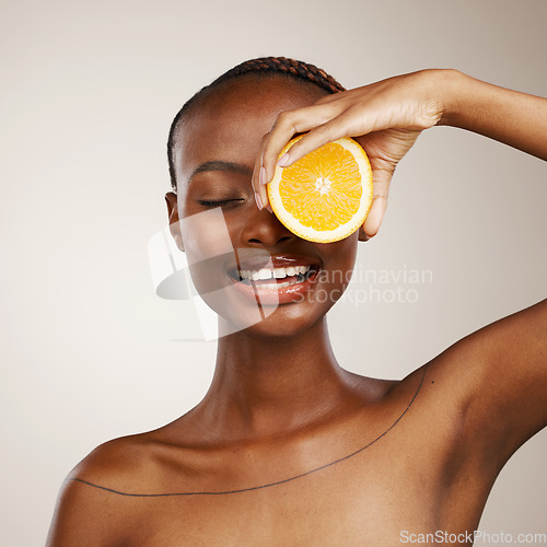 Image of Black woman, orange fruits and beauty in studio for vitamin c, vegan cosmetics and facial on brown background. Happy model, citrus and nutrition for natural skincare, organic benefits and detox diet