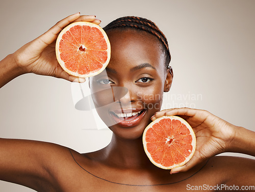 Image of Woman, grapefruit and portrait of beauty in studio for vitamin c, vegan cosmetics and glow on brown background. Face, happy african model and citrus nutrition for healthy benefits of natural skincare