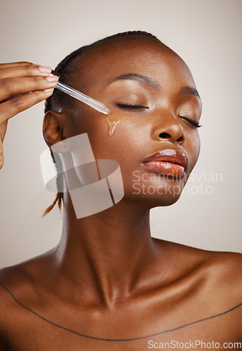 Image of Woman, beauty and oil on face in studio for aesthetic skincare, dermatology and glow on brown background. African model, facial cosmetics and dropper of hyaluronic acid, liquid and serum for shine