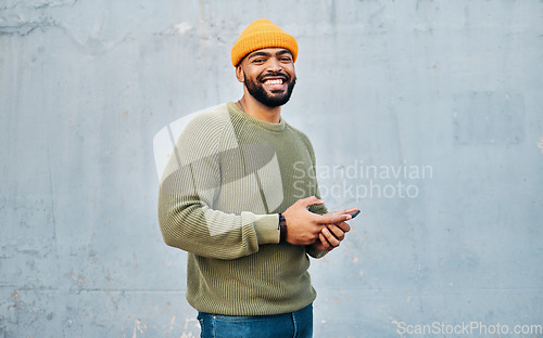 Image of Phone, portrait and young man by wall networking on social media, mobile app or the internet. Technology, happy and person from Colombia scroll on website with cellphone in city by gray background.