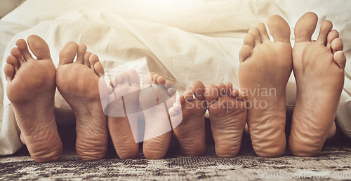 Image of Feet, love and family in bed together to relax on a weekend morning in their home with flare. Mother, father and children with blankets sleeping in the bedroom to rest while dreaming closeup