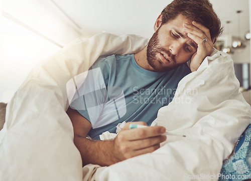 Image of Thermometer, stress and sick man on a sofa with headache, fever or influenza crisis in his home. Anxiety, high temperature and male person with vertigo, risk or fear of covid infection in living room