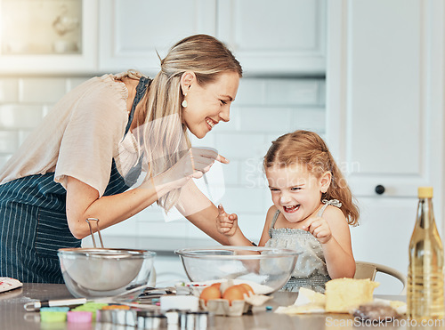 Image of Mom, girl kid and teaching for baking, development and laugh with bonding, love and care in family home. Cooking, funny mother and daughter with bowl, flour or eggs on table, kitchen or help for food