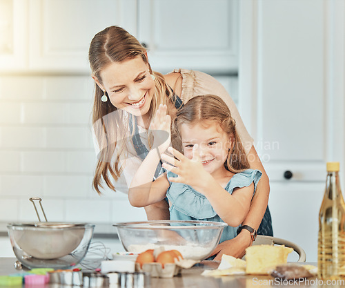 Image of Mom, girl child and teaching for cooking, development and skills with bonding, love and care in family home. Baking, mother and daughter with smile, flour and eggs on table, kitchen and help for food