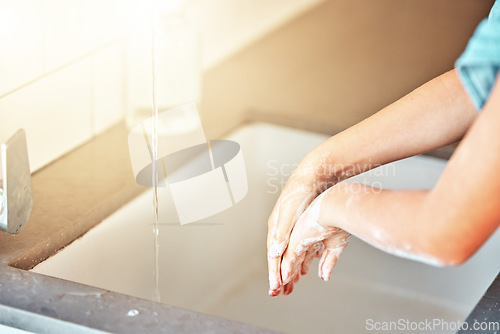 Image of Soap, washing hands and kid with water for cleaning, hygiene and wellness in bathroom at home. Health, child development and palms of young girl with foam for protection for germs, virus and bacteria