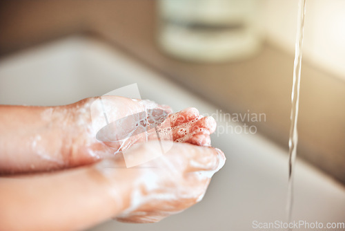 Image of Soap, washing hands and kid by sink for cleaning, hygiene and wellness in bathroom at home. Health, child development and palms of young girl with water for protection for germs, virus and bacteria