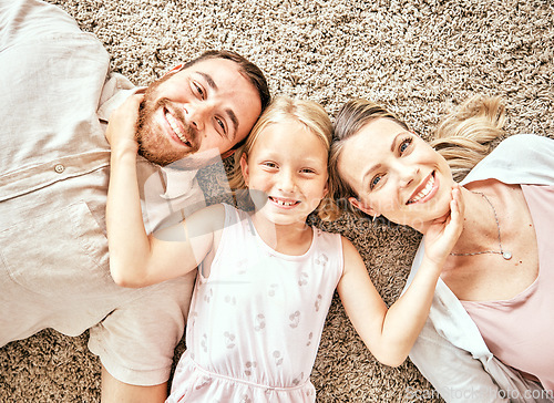 Image of Happy, portrait and child with parents in the living room bonding and relaxing together at home. Happiness, love and girl kid laying with mother and father from Australia on floor in lounge at house.