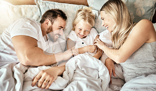 Image of Bed, top view and happy family bond with tickle, games and laughing in their home together. Bedroom, fun and above parents with girl child in a house with care, support and love, security or playing