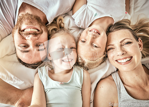 Image of Happy, smile and portrait of family on a bed for bonding and relaxing together at modern home. Happiness, love and top view of girl children laying with parents from Australia in bedroom at house.