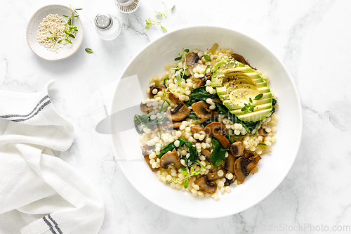 Image of Couscous with avocado, spinach and sauteed champignon mushrooms with onion, top down view