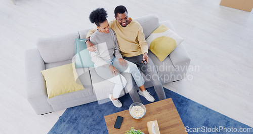 Image of Black couple, top view and couch in living room, tv and relax with popcorn, movies and funny comedy. Man, woman and hug for bonding together, streaming and happy in lounge, couch and remote control