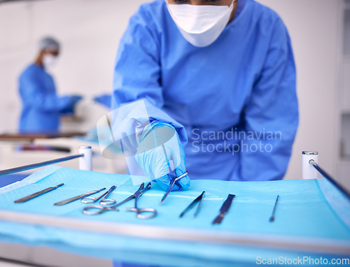 Image of Nurse, surgery and prepare tools in operation, medical equipment and scissors for procedure. Surgeon, hospital and scrubs for protection, medical service and surgical tools in theatre for emergency