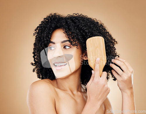 Image of Hair, woman brush curls and beauty, routine or treatment for shine, cosmetic care and smile on studio background. Wellness, haircare and growth with strong texture and bamboo tools, volume and afro