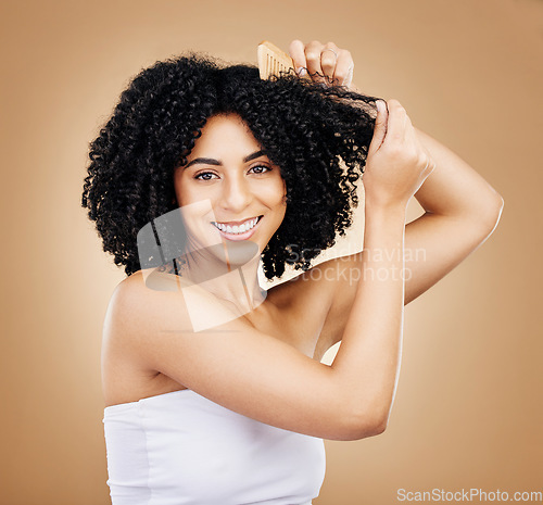 Image of Afro, hair comb and portrait of woman in studio for beauty, natural growth and grooming on brown background. Happy model brush curly hairstyle texture for salon aesthetic, keratin treatment and care