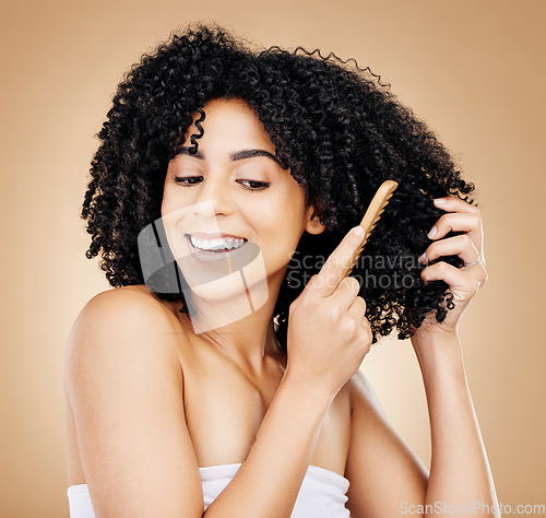 Image of Curly, hair comb and smile of woman in studio for beauty, natural growth or coil texture on brown background. Happy model, haircare tools and brush afro for salon aesthetic, keratin cosmetics or care