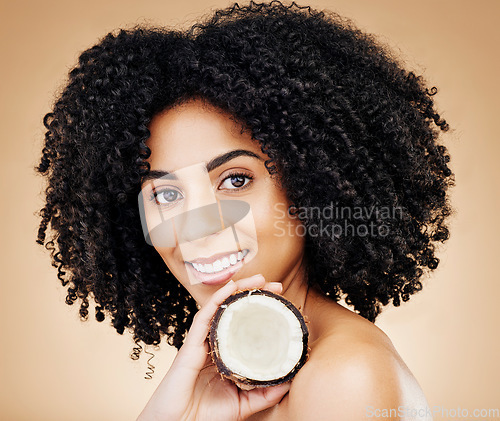 Image of Woman, portrait and hair, coconut with shine and beauty, organic salon treatment for strong texture on studio background. Face, skin and natural cosmetic product for growth with haircare and fruit