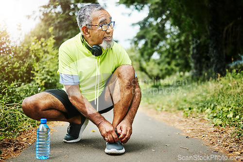 Image of Senior man, tie and shoes in fitness for running, workout or outdoor exercise on road, nature or asphalt. Mature male person and tying shoe getting ready or preparation for path, cardio or run