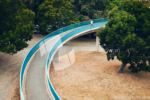 Image of Man, running and above bridge in nature, countryside or outdoor in environment with path in woods. Athlete, run or walking on road for cardio, fitness or exercise in forest with eco infrastructure