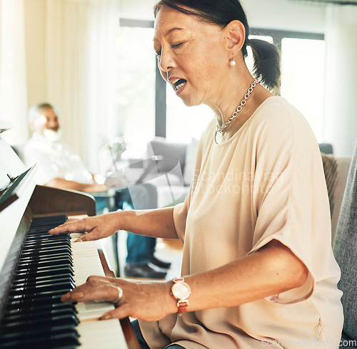 Image of Singing, piano and senior woman playing for music with husband in living room for bonding and entertainment. Instrument, practice and elderly Asian man and woman in retirement with keyboard at home.