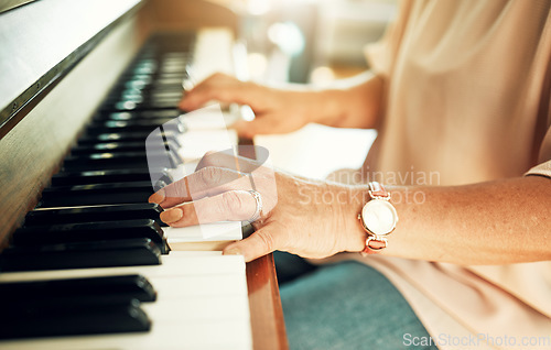 Image of Hands, closeup and woman playing piano for music in living room for musical talent practice. Instrument, song and zoom of senior female person in retirement enjoying keyboard at modern home.