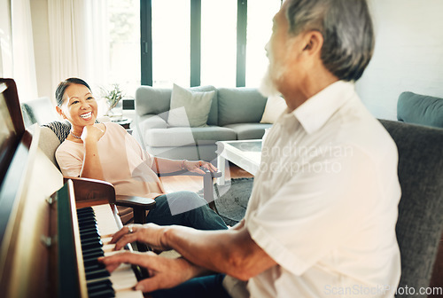 Image of Happy, piano and senior man playing for music in living room with wife for bonding, entertainment or having fun. Instrument, smile and elderly Asian couple in retirement enjoy keyboard at modern home