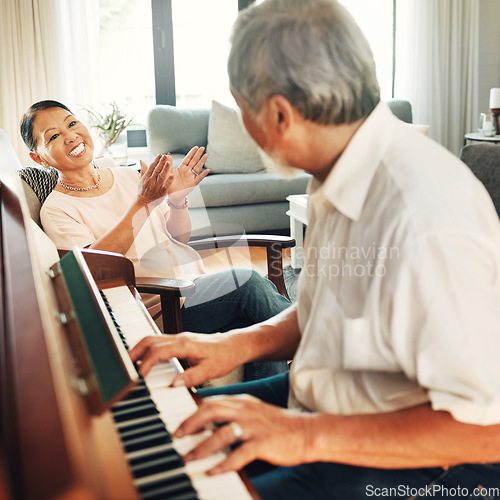 Image of Smile, piano and senior man playing a song to his wife for music in living room with bonding or entertainment. Happy, instrument and elderly Asian couple in retirement enjoy keyboard at modern home.