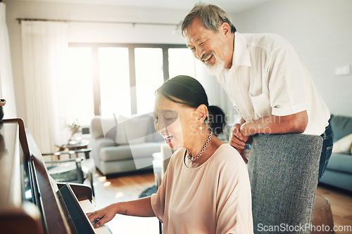 Image of Piano, music and a senior asian couple in their home together for love or romance in retirement. Smile, art or creative with a happy elderly man and woman playing an instrument in their house