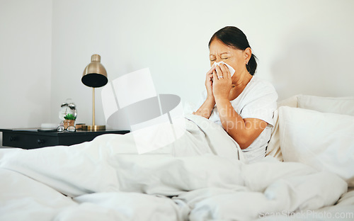 Image of Senior woman, blowing nose and sick in bed with allergy, virus from bacteria with health and wellness at home. Sinus infection, medical condition with toilet paper for illness and sneezing in bedroom