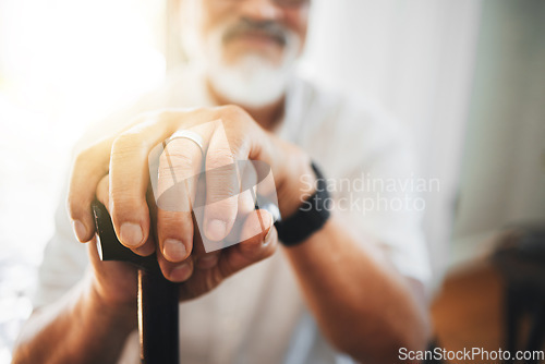 Image of Hands, walking stick and elderly man in home for support, healthcare or help in retirement. Closeup, lonely senior with disability and aid of cane for parkinson, arthritis or rehabilitation of stroke