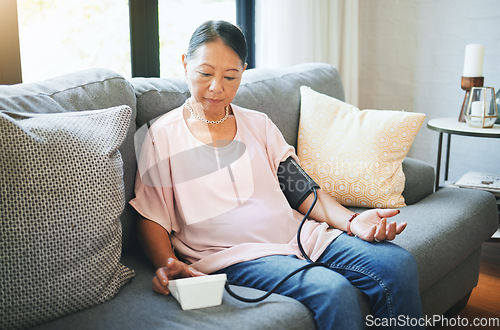 Image of Blood pressure, healthcare and senior woman in living room with equipment for hypertension. Sick, illness and elderly female person in retirement with medical tool in the lounge of modern home.