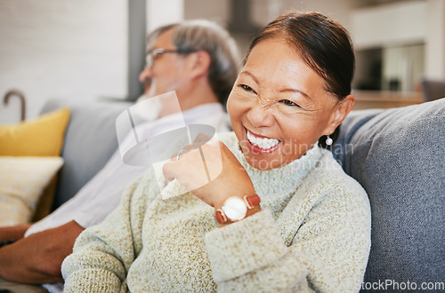 Image of Mature, woman and laugh on sofa with smile in lounge for joke on holiday, vacation or retirement. Face, elderly couple or asian person for funny, goofy or silly talk and relax with husband in home