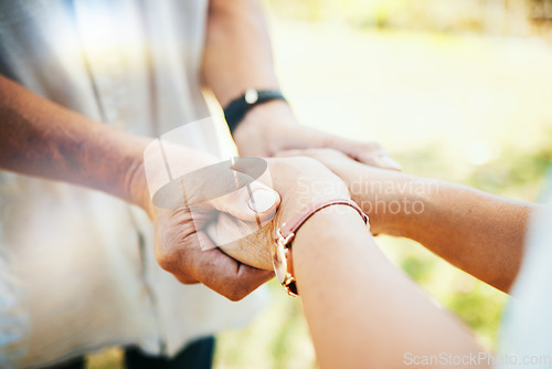 Image of Holding hands, closeup and couple in park, sunshine and care with bonding, faith or pray in nature. People, trust and support for empathy, romance or comfort in backyard, lawn or outdoor for kindness