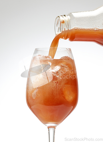 Image of fresh juice pouring into cocktail glass 