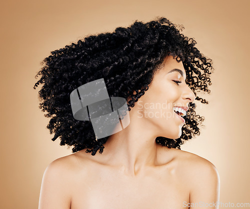 Image of Happy woman, curly and hair shake afro for fun on studio background in healthy hairstyle growth, texture or frizz treatment. African beauty model, energy and change by shampoo transformation results