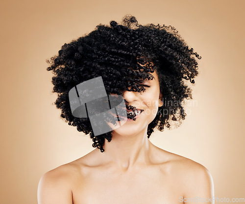 Image of Woman, curly and hair wind in afro fun on studio background for healthy hairstyle growth, texture and frizz treatment. African beauty model, shake energy and change by shampoo transformation results