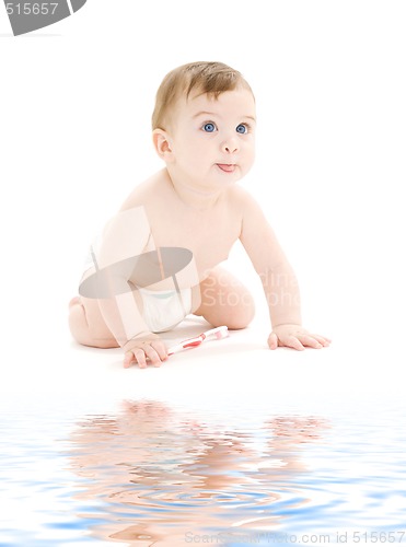 Image of baby boy in diaper with toothbrush sticking tongue out