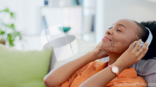 Image of Music headphones, relax or black woman on couch streaming a song or calm sound on radio playlist. African girl, peace or happy zen person listening to a podcast audio on subscription on home sofa