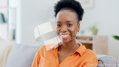 Image of Portrait, relax and smile with a black woman on a sofa in the living room of her home during the weekend. Face, freedom and afro with a happy young person alone in the lounge of her apartment