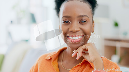 Image of Portrait, freedom and smile with a black woman on a sofa in the living room of her home during the weekend. Face, relax and happy with a confident young person alone in the lounge of her apartment