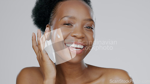 Image of Portrait, cream and face of black woman in studio for beauty, dermatology and aesthetic makeup on grey background. Happy model, sunscreen lotion and facial cosmetics for clean skincare, glow or shine